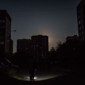 A local is walking with a torchlight in Luhansk. The home of 500k people, Luhansk had to electricity for 2 months during the summer