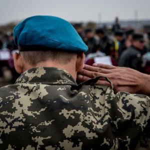 A marine veteran salutes at the funeral ceremony of unidentified Ukrainian servicemen in Dnipropetrovsk