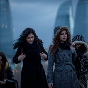 Girls walk on the Caspian Sea embankment in Baku. The distinctive Flame Towers can be seen in the background.