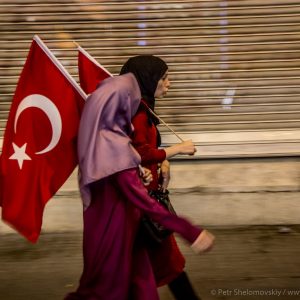 Covered female Erdogan supporters waving Turkish flags as they walk up Istiklal street of Istanbul, Turkey