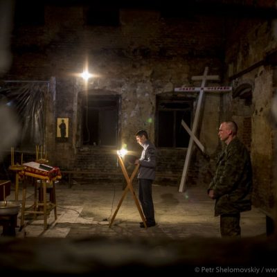 Uniformed separatist soldier stands during Easter mass in destroyed Orthodox church in Petrovskiy district of Donetsk
