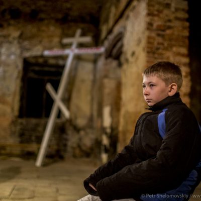 Young boy during Easter mass in destroyed Orthodox church in Petrovskiy district of Donetsk