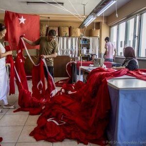 Flag factory workers pack their product for delivery. The factory works 24x7 to supply growing demand. Istanbul, Turkey