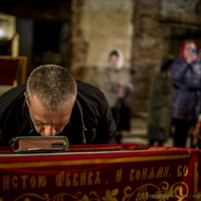 A man kissing the Bible during Easter mass in destroyed Orthodox church in Petrovskiy district of Donetsk