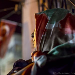 An elderly lady is looking at the Turkish flag hanging on the corner of her house in the Asian part of Istanbul, Turkey