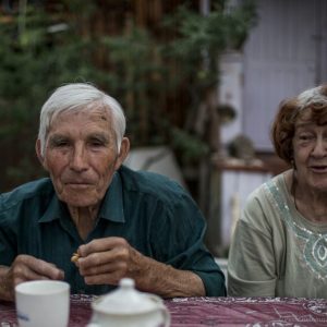 Vladimir and Herolda have tea in front of their house.