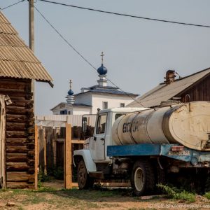 Soviet era water tanker truck is parked behind the church in Khuzhir village in Olkhon island. 