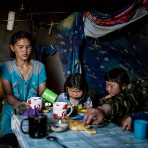 Pavel Yarotskiy, his wife Izolda and their children are having tea in their chum in the family herding camp on the left bank of Yenisey river in West Siberia